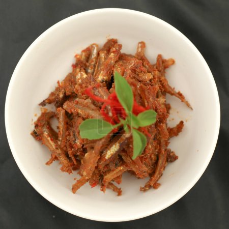 Sambal balado teri ist gebratene Sardelle mit scharfer und scharfer Chili-Sauce. Traditionelle indonesische Küche. Nahaufnahme.