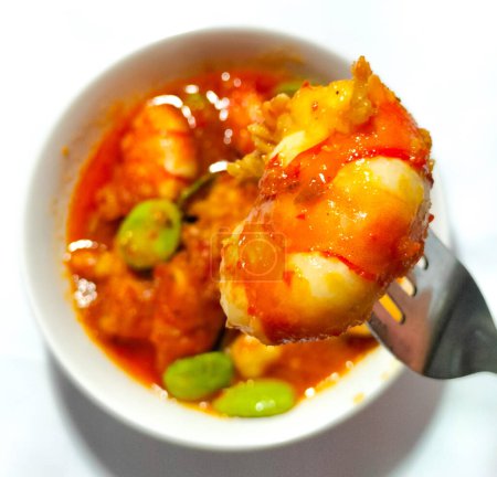 Petai or Pete with Shrimp, cooked with mashed red chili. This food is called Balado Udang Pete, isolated on dinner preparation. Selective focus.