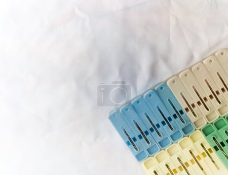 A set of multi-colored clothespins on a white background. Multicolored plastic clothespins for laundry. Selective focus.