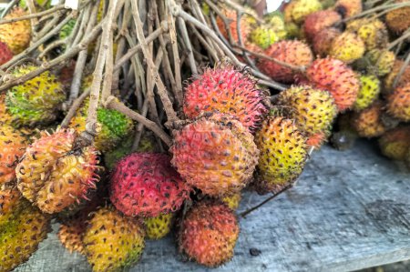 Asian native rambutan fruit. A pile of rambutan fruit sold at a traditional market in Ungaran, Indonesia. Selective focus.