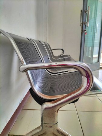 Vista de una silla de metal negro con bordes blancos. Interior de un banco en la sala de espera del paciente. Enfoque selectivo.