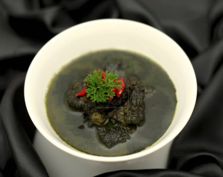Fried cuttlefish with squid ink sauce - seafood style. Side view.