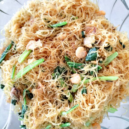 Revuelva los vermicelli de arroz frito con camarones y col rizada china. Enfoque selectivo.