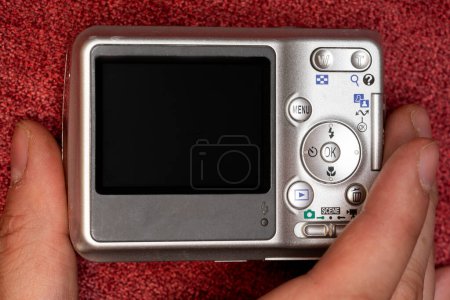 Téléchargez les photos : Main tenant une caméra vintage avec espace de copie dans l'écran de la caméra - en image libre de droit