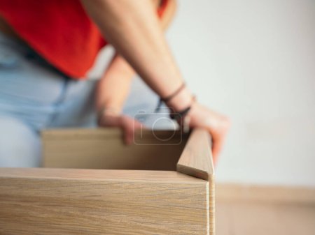 Foto de Persona en ropa casual dedicada a la carpintería, montaje de tablones de madera para muebles - Imagen libre de derechos