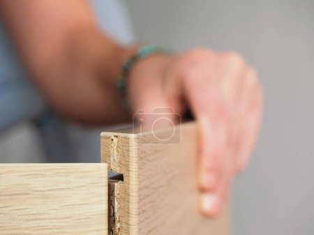 Foto de Vista detallada de las manos que encajan piezas de madera, destacando las complejidades del montaje de muebles - Imagen libre de derechos