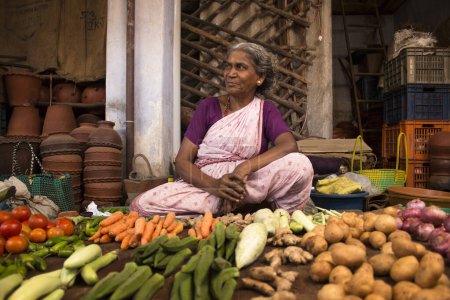Foto de Esperemos que una anciana comience su mañana vendiendo todas sus verduras frescas. - Imagen libre de derechos