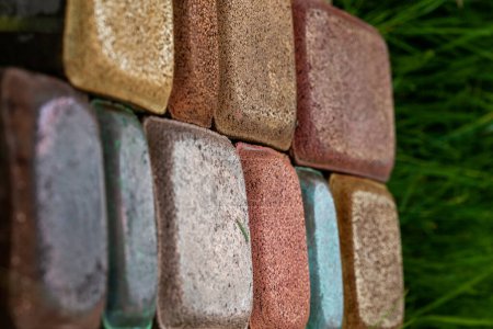 Photo for Bricks. Paving tiles. Colored stones. Texture of paving tiles. Cement products. Sidewalk in grass. Tile with embedded metal. - Royalty Free Image