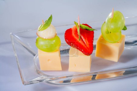 Cheese and various cheese compositions with fruit. Hard cheese with different textures and colors. A variety of different types of hard cheese. Small pieces of cheese with fruit.