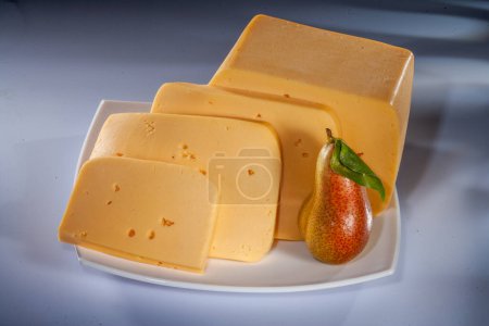 Käse und verschiedene Käsekompositionen mit Früchten. Hartkäse mit unterschiedlichen Texturen und Farben. Verschiedene Hartkäsesorten. Kleine Käsestücke mit Früchten.