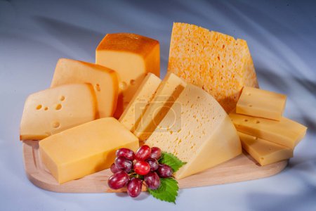 Queso y varias composiciones de queso con frutas. Queso duro con diferentes texturas y colores. Una variedad de diferentes tipos de queso duro. Pequeños trozos de queso con fruta.