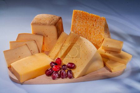 Queso y varias composiciones de queso con frutas. Queso duro con diferentes texturas y colores. Una variedad de diferentes tipos de queso duro. Pequeños trozos de queso con fruta.