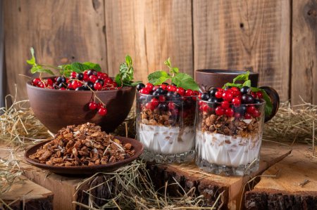 Foto de Fresh berries and yogurt. Healthy breakfast with berries. Healthy food and diet. Pottery and hay. Front view. - Imagen libre de derechos