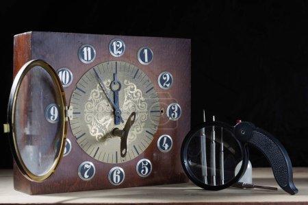 Foto de Relojes viejos y herramientas. Reparación de relojes viejos. Relojes y destornilladores. Lupa y destornilladores. Vista frontal. - Imagen libre de derechos