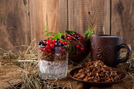 Téléchargez les photos : Breakfast with milk, granola and berries. Pottery and hay. Front view. - en image libre de droit