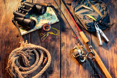 Téléchargez les photos : Pêche filant avec une ligne de bobine. Articles de pêche sur un fond en bois. Jumelles et corde. - en image libre de droit