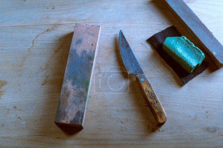 Téléchargez les photos : Vieux couteaux de cuisine et pierre à aiguiser. Des pierres à aiguiser et un vieux couteau. Restauration du couteau. Vue d'en haut. - en image libre de droit