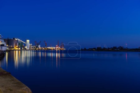 Foto de Edificio iluminado que reflexiona sobre el agua del puerto nocturno - Imagen libre de derechos