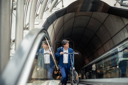 An urban businessman is seen commuting to his destination using an electric folding bike in the public transportation system. This image highlights his commitment to a sustainable and efficient lifestyle in the urban environment, combining the practi