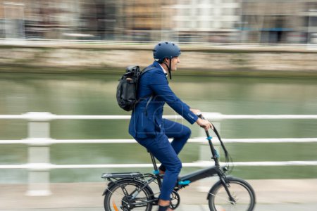 Foto de Un disparo dinámico que captura el movimiento de un hombre de negocios que viaja por la ciudad en su bicicleta eléctrica, promoviendo el transporte sostenible - Imagen libre de derechos