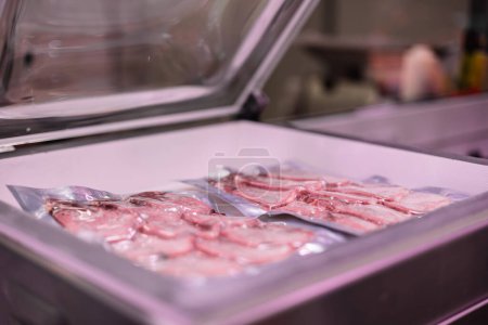 Nahaufnahme vakuumversiegelter Hühnerbrüste in der Verpackungsmaschine. Die Szene unterstreicht das Vakuumsiegelverfahren, das dazu beiträgt, Frische zu bewahren und die Haltbarkeit von Fleischprodukten zu verlängern, wodurch die Qualität für die Verbraucher gewährleistet wird.