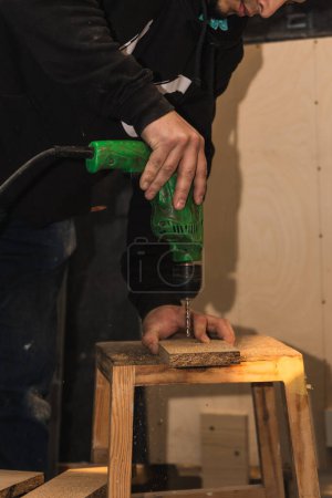 vertical retrato carpintero latino utiliza su taladro con precisión para hacer muebles en su taller de carpintería. La imagen captura el enfoque meticuloso del artesano, empleando su habilidad y herramientas especializadas para dar vida a piezas de madera con el