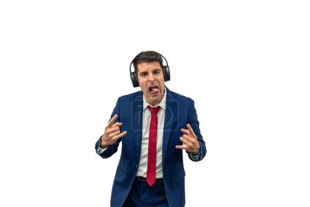 businessman in a suit wearing headphones and listening to heavy metal music. With a rebellious gesture of making the horn sign with his hands and sticking out his tongue white background
