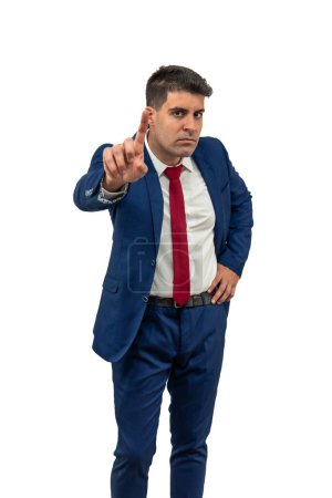 vertical displeased expression of a businessman as he looks contrarily at the camera, with a furrowed brow, shaking his head and raising a finger in denial, expressing anger white background