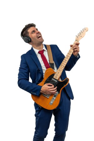 Foto de Hombre de negocios motivado vertical grita mientras toca un solo de guitarra eléctrica. Con pasión, encarna la creatividad corporativa y la expresión, energizado por su actuación musical fondo blanco - Imagen libre de derechos