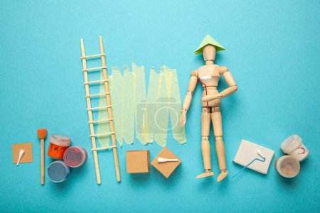 Photo for Wooden people paints walls in apartment, repair and renovation room of design and decor. Paint buckets and step ladder. DIY house work. - Royalty Free Image