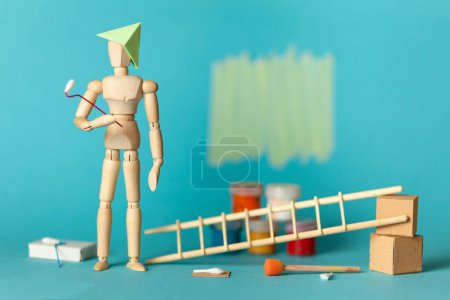 Photo for Wooden figure of man paints walls in apartment room, repair and renovation of design and decor. Paint buckets and a step ladder. DIY indoors work. - Royalty Free Image