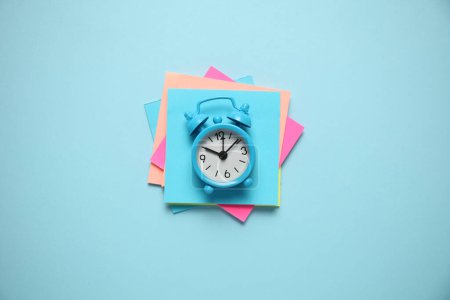 Photo for Blue alarm clock and paper reminder. Time management, priorities, efficiency, control and goals. - Royalty Free Image