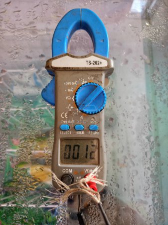 Photo for Ampere pliers are being used to measure freezer temperature - Royalty Free Image