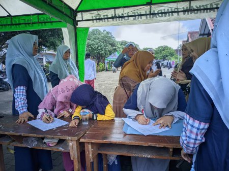 Téléchargez les photos : Un grand rassemblement de musulmans dans l'une des régions de Java oriental lors d'une cérémonie tribale traditionnelle dans le style de la culture islamique sunnite. Photo prise le 02 décembre 2023 - en image libre de droit