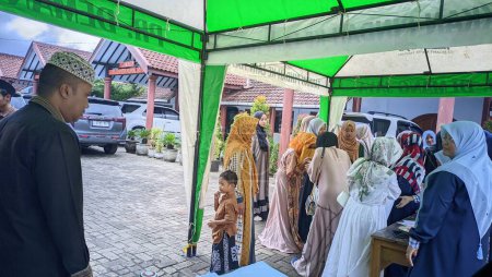 Téléchargez les photos : Un grand rassemblement de musulmans dans l'une des régions de Java oriental lors d'une cérémonie tribale traditionnelle dans le style de la culture islamique sunnite. Photo prise le 02 décembre 2023 - en image libre de droit