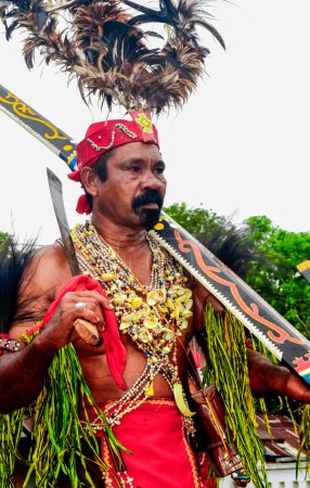 Téléchargez les photos : Maluku, Indonésie - 5 novembre 2014 : Homme habillé en danse de Cakalele. Cakalele Dance est une danse de guerre typique de Maluku, Indonésie - en image libre de droit