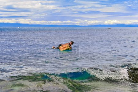 Téléchargez les photos : Un enfant nage sur la plage - en image libre de droit