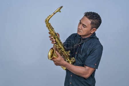 Photo for A man holding a Saxophone - Royalty Free Image