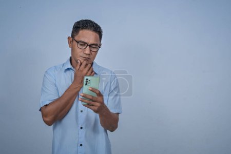 Man in glasses holding smartphone