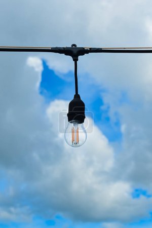 Incandescent light bulbs on sky and clouds background