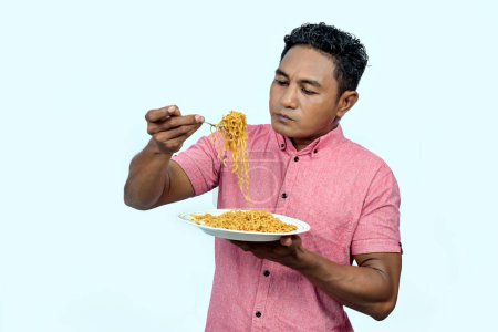 Un homme asiatique mange des nouilles