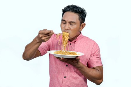 An Asian man is eating noodles