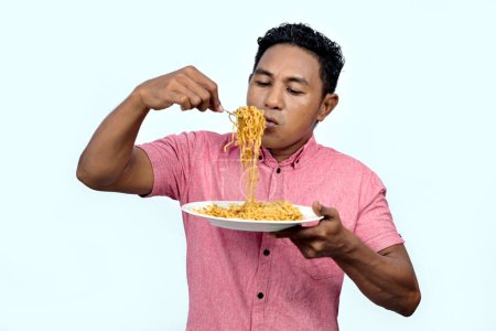 An Asian man is eating noodles
