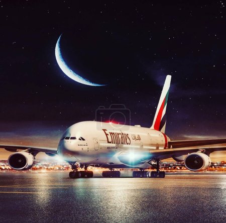 Foto de PAKISTAN, KARACHI, 10 ENERO 2024 Un Emirates Airbus A380-800 super jumbo, el avión de pasajeros más grande del mundo está esperando a los pasajeros y cargando en la terminal de Karachi Heathrow durante la noche. - Imagen libre de derechos