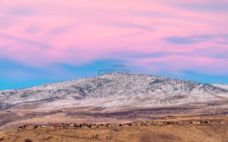 Photo for Snow capped mountain at sunset with magenta skies above a ridge line of houses in the Reno Sparks Nevada area. - Royalty Free Image