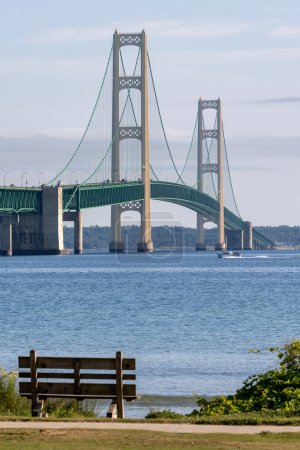 Photo for Empty park bench with the Mackinaw Bridge in the distance - Royalty Free Image