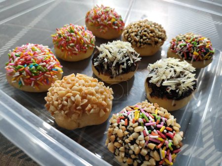 Téléchargez les photos : Mini beignets sont décorés avec des garnitures colorées, ce qui rend ce gâteau adapté comme fond. - en image libre de droit