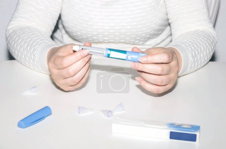 Photo for Female hands holding an insulin pen. Ozempic Insulin injection pen or insulin cartridge pen for diabetics. Medical equipment for diabetes parients. - Royalty Free Image
