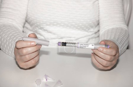 Photo for LantusInsulin injection pen or insulin cartridge pen for diabetics. Medical equipment for diabetes parients. Woman holding an injection pen for diabetic. - Royalty Free Image