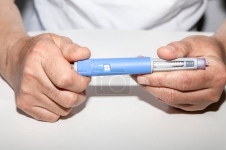 Photo for Ozempic Insulin injection pen or insulin cartridge pen for diabetics. Man holding an injection pen for diabetic. Medical equipment for diabetes parients. - Royalty Free Image